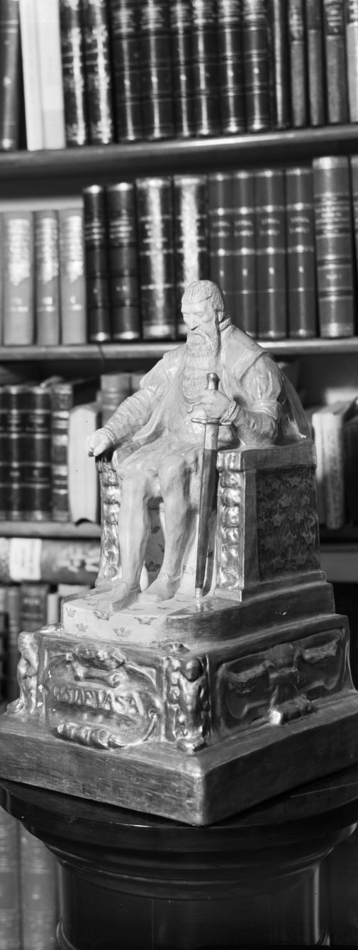 Modell av staty av Gustav Vasa. I bakgrunden böcker.